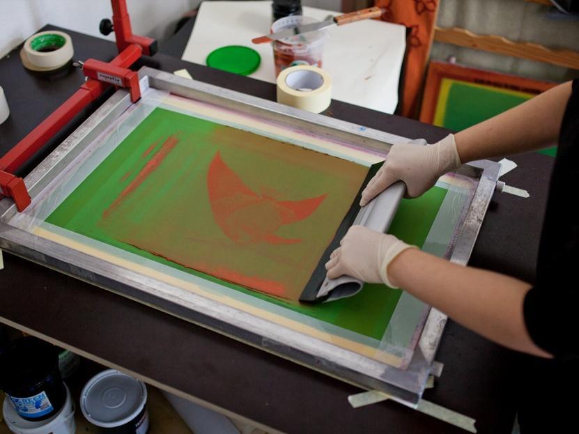 for a multi-color image A squeegee forces ink through silk