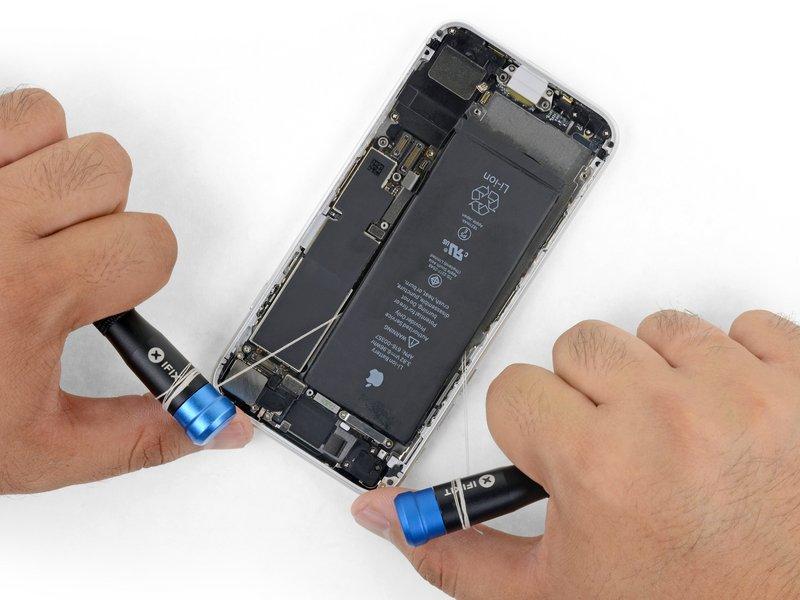 Flip the iphone back over and thread a strong piece of string (such as dental floss or a length of thin guitar string) underneath the battery.