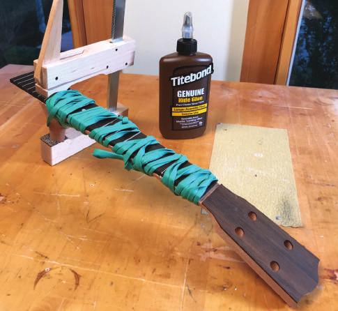 It is easiest to remove this with a very sharp chisel. Simply lay the back of the chisel along the face of the fingerboard and gently remove any dried glue.