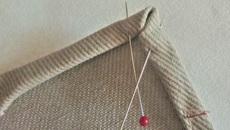 Create a diagonal point at each bottom corner. This is why you left the bottom 1" of the inside hemmed edges un-sewn.