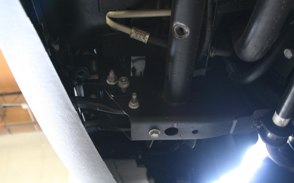8. Remove 21mm nuts (2 per side) from the bolt strips holding the bumper brackets to the frame.