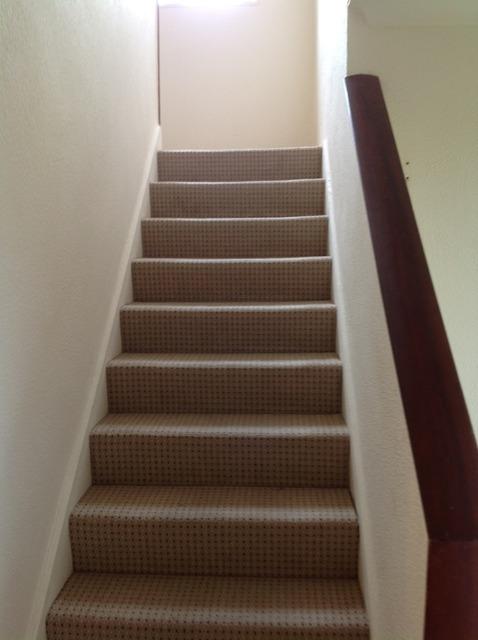 Stairs And Landing Doors & Hardware White painted wooden skirting board with painted over defects beneath.