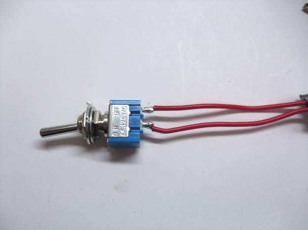 oval. As shown in the photo, solder the other end of the red wire to the outer terminal of the toggle switch.