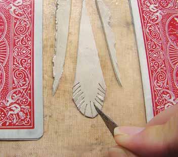 Use the edge of one playing card to cut the clay shape following the diagonal lines of the sides of the teardrop and leaving the rounded lower edge intact.