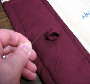 Hand sew the loop together and then hand sew it onto the panel.