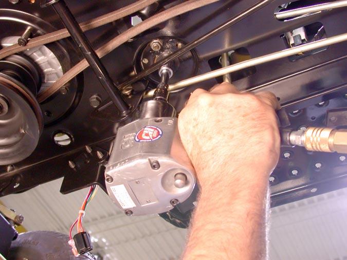 Using a 5/8 box end wrench on the upper side of the shoulder screw and an air gun with a ½