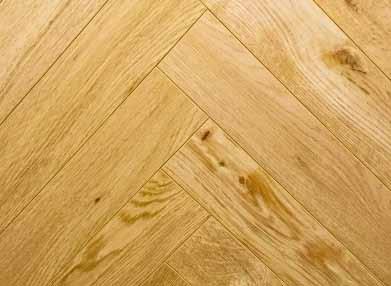 44 12mm LAMINATED NATURAL OAK HERRING- BONE FLOORS A Natural Oak Herringbone laminate floor with natural knots and variants in tone throughout