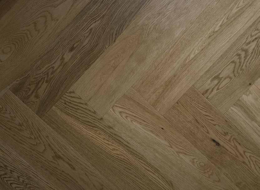 51 12mm LAMINATED SMOKED HERRING- BONE FLOORS A Smoked Oak Herringbone laminate floor with natural knots and variants in tone throughout each
