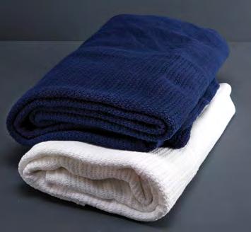 ESSENTIAL BLANKETS Essential cotton cellular blankets shown in White and Navy Blue. Essential Velourlux blanket shown in Ivory.