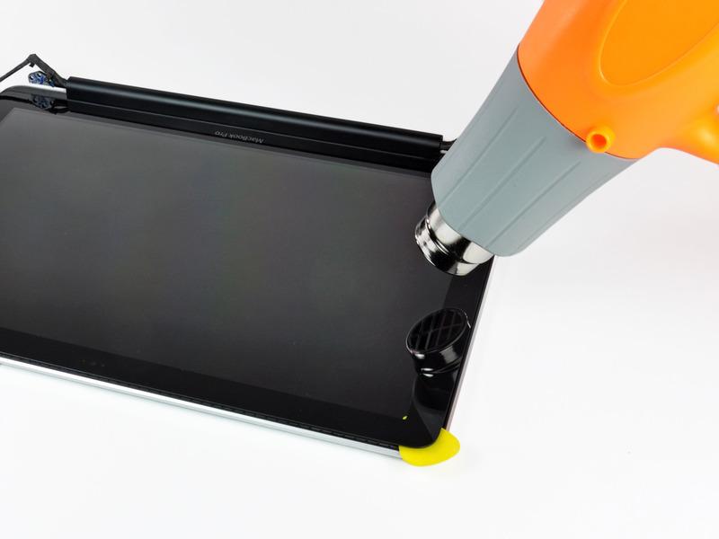 Step 25 Use a heat gun to soften the adhesive under the black strip along the left side of the front glass panel.
