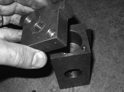 Lift out slide block without losing brass antiscore plug (see Figure 8). Figure 9. Slide block end-cap removal. 11.