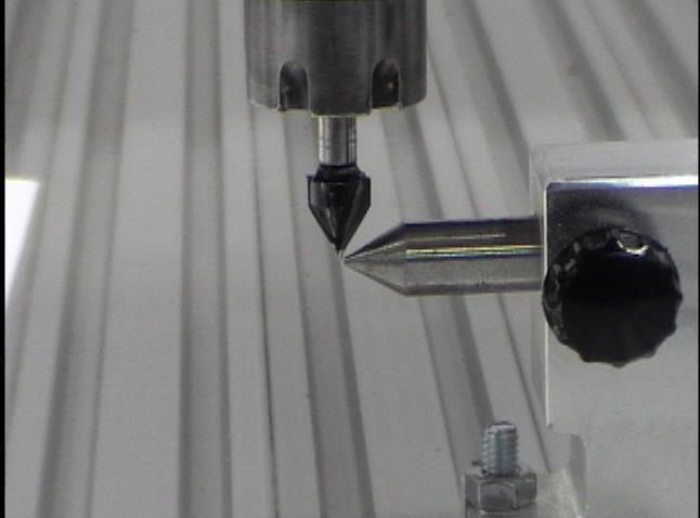 align the tailstock point with a point of the V-bit in the spindle. This is the centerline at the tailstock. Tighten the front bolt of the tailstock.