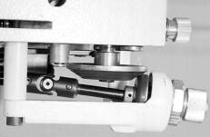 - Loosen the screws ( and ) of the holder () and remove the holder () with the telescopic shaft () and the driven wheel from the machine.