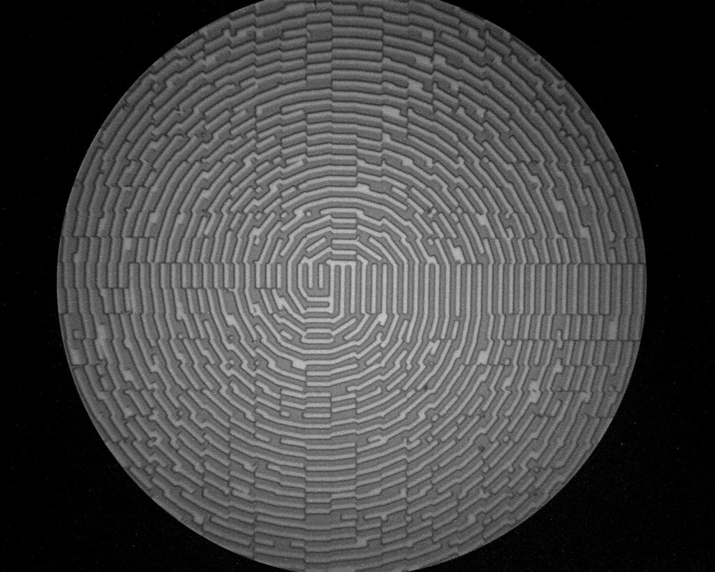 Figure 8: (A) Photograph of a 42 mm x 42 mm computer-generated hologram written on the ZP-150. Minimum features are ~375nm. (B) Micrograph of ring resonator pattern with output coupler.