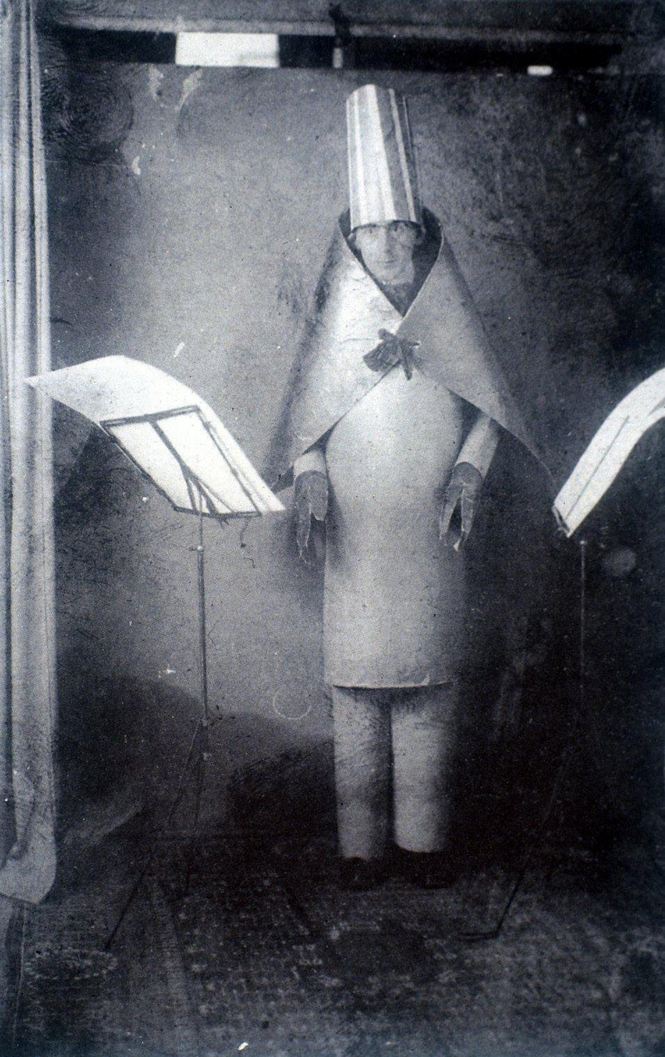 Hugo Ball Performing at Cabaret Voltaire (1916) Artwork description & Analysis: Ball designed this costume for his performance of the sound-poem, Karawane, in which nonsensical syllables uttered