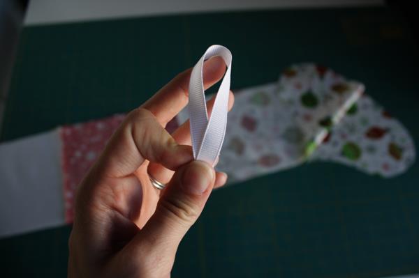 Take the 6 of ribbon and make it into a loop. Place it between your lining layers on the BACK side (heel side) of the stocking with the loop on the inside.