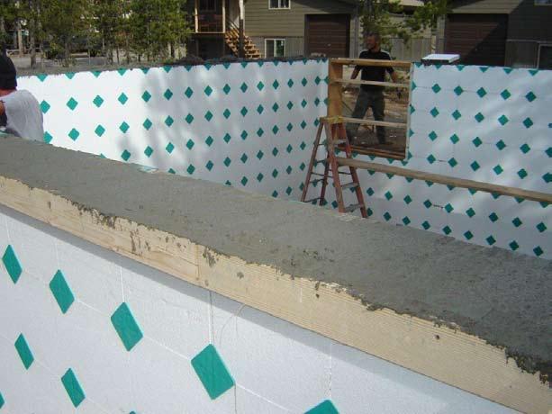 The top of the wall is screeded, troweled smooth, and anchor bolts are set. Once the concrete is sufficiently cured, bracing can be removed and construction can continue.