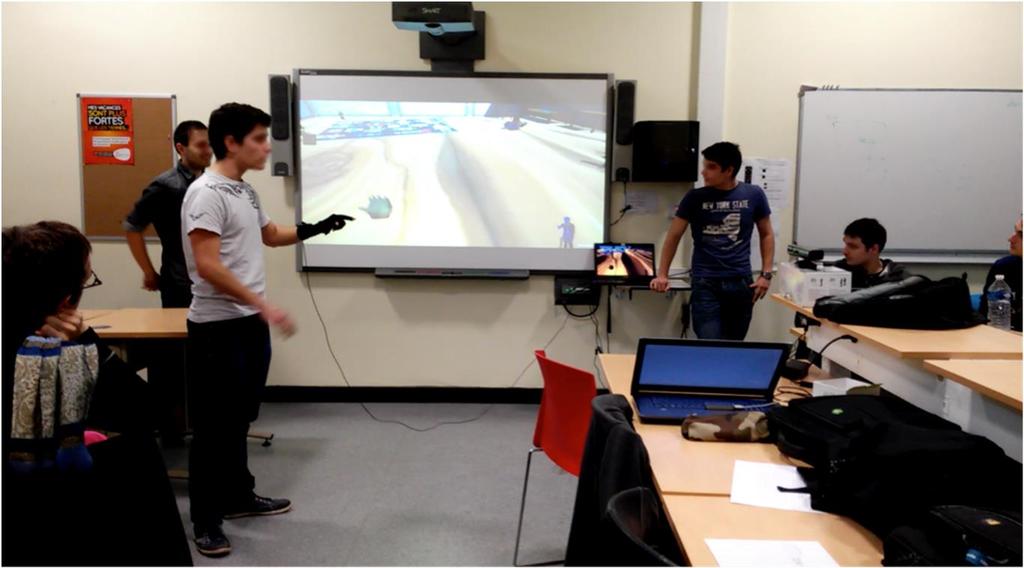 Fig. 1. Students presenting their work at the VR Lab Videos showing several moments of the final project presentation day and several project trailers are available at our channel http://bit.