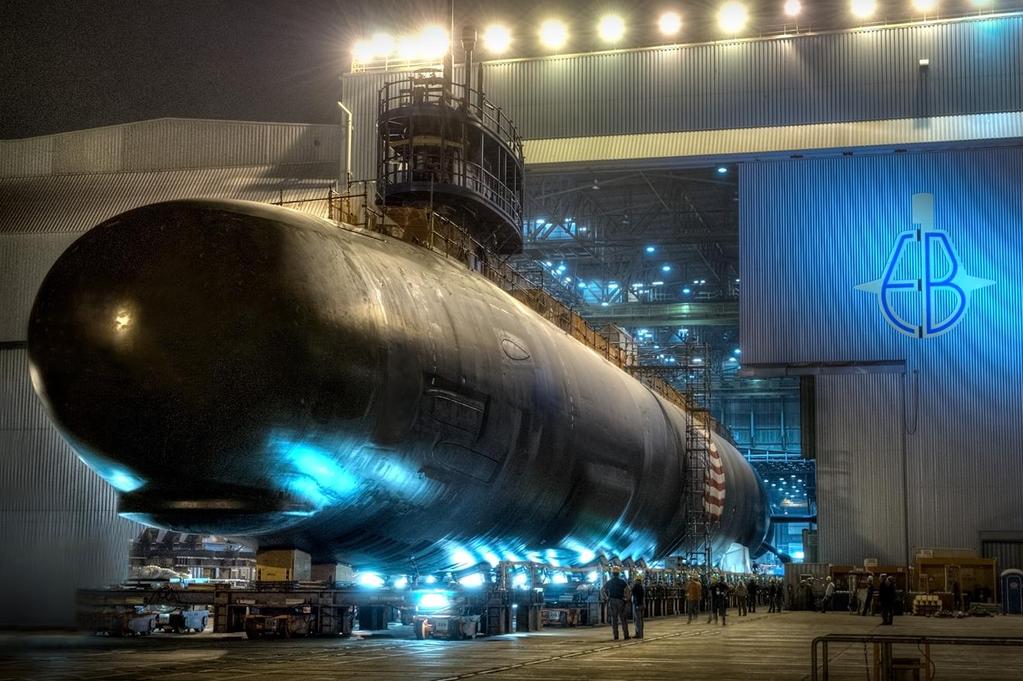 A VIRGINIA-class submarine moves on rails out of the 260 building after final assembly.