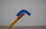 Tape it to the eraser of the pencil and bend it so that it hangs down over