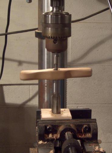 Turn the handle to advance the tap until the tap bottoms out. Then remove the tap and remove the wooden faceplate from the drill press.