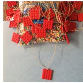 Lego Necklaces Supply of flat square Lego pieces String Beads Drill Drill a small hole through every flat square Lego piece Tie a string though each hole creating a