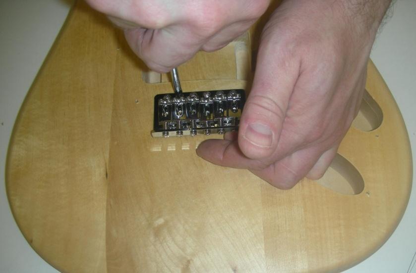 Take the vibrato bridge and sit it into the routed section toward the rear of the body, allowing the sustain block (the