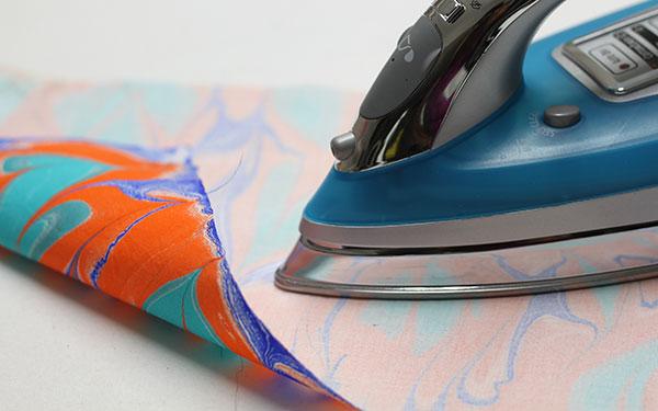 8. Heat Set Paints on Marbled Fabrics Iron on the wrong side on med - high heat setting for at least 5 mins, using pressing sheets to protect your iron and ironing board.