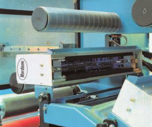The system combines precise adhesive placement and web handling into a single module that easily retrofits into most roll-fed printing presses and web