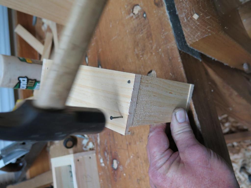 Next, spread some glue on both ends of the drawer back and nail it in from either side being sure it is even with the tops of the
