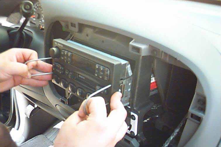With your hands, grab one corner and pull until the plastic dash panel completely pulls away from the main body of the dash. The Ford radio is snapped into the vehicles dash.