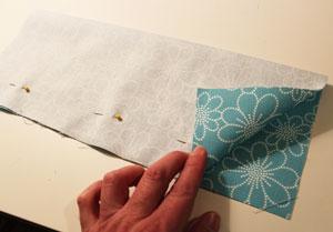 To prepare the inner pockets, cut two pieces of fabric to 15" wide by 12" high. Fold the fabric in half widthwise (long edges aligned) with the right sides together.