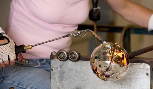 Glassblower Melted glass is soft, like very thick glue. A glassblower scoops up a blob of hot, soft glass with the end of a long metal pipe.