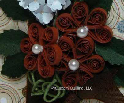 Five petal quilled flowers have pearl centers, this time with