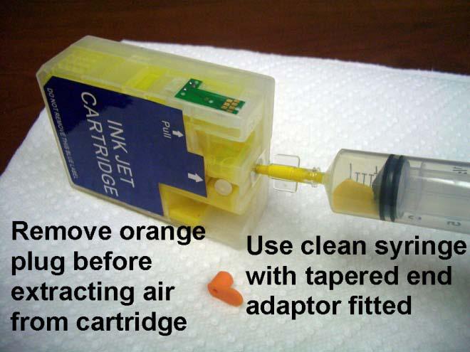 Remove the orange rubber plug from the air port. Take the syringe you used to fill the cartridges with ink, remove the needle, and push a tapered end adaptor onto the end of the syringe.