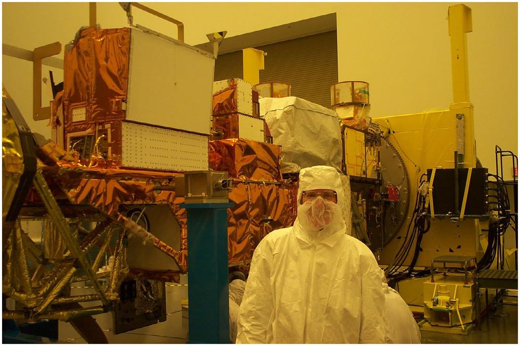 Figure 4. Claire in a TRW cleanroom with the Aqua spacecraft, 19 December 2001. Source: Photo by Mike Comberiate. but it is still going strong over 15 years after launch.