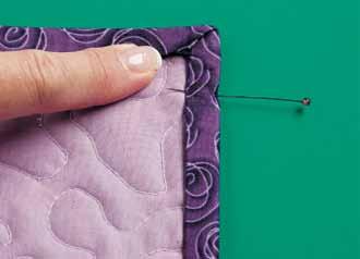 Pin or clip binding in place and stitch to quilt back by