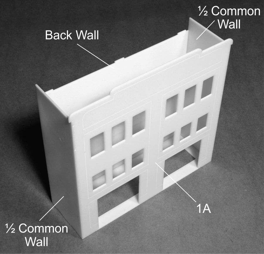 Place the tabs of wall (1A) into the slots on Side (1) of the base and glue into place. Glue one half of the Common wall to either side of part (1A).