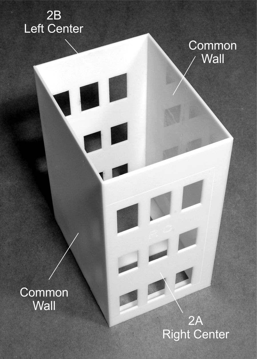 Place the tabs of the right center wall (2A) into the slots on Side (1) of the Base and glue into place. Glue one Common wall to either side of part (2A).