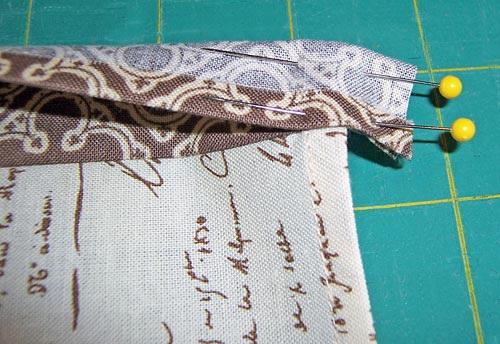 Turn the binding ends right side out and wrap the binding over to the wrong side of the napkin, covering the raw edges.