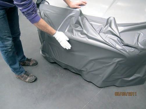 during the application process. Check once again whether the piece of vinyl is big enough for the car part to be wrapped. Then remove the backing paper and position the vinyl loosely on the car.