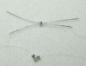 Pull the bead to make sure it is in the center of your thread so that both needles are an equal distance away from the