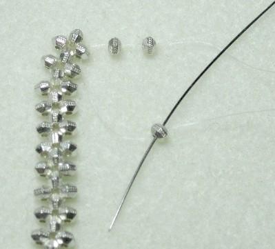 Take your top needle and go through 2 spacer beads. Take your bottom needle and go through 1 spacer bead.