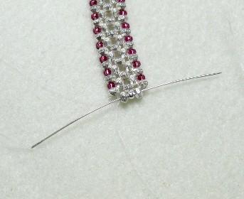 Take your left needle and go through the bottom left spacer bead, the center round bead and the spacer