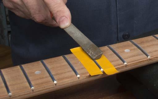 Color the fret tops with a blue permanent marker to prepare them for leveling.