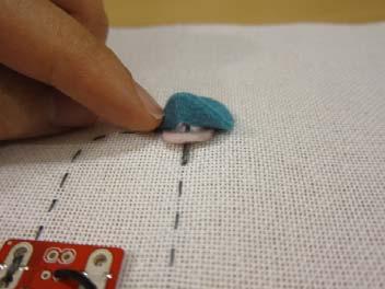 Stitch so that the thread spans across the top of the hole and is separated from the bottom thread by the felt.