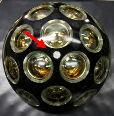 (a) Figure. (a) Photo of the digital optical module (DOM). The photo-multiplier tubes are clearly visible. The piezo ceramic hydrophone is visible as the small white dot.