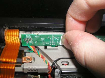 Using your thumb and forefinger, grab the inverter board as shown, and gently push it towards the