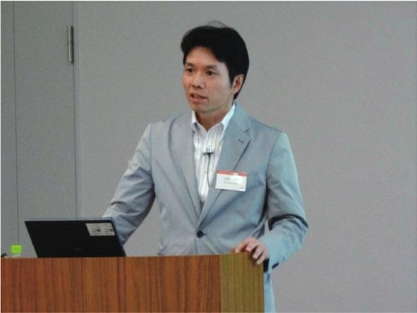 Photo 2. Naonori Ueda, Director of CS Labs, giving the keynote speech. Photo 3. Research talk by Dr. Naoyuki Hironaka. social systems.