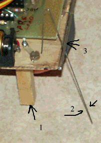 When the robot hits an object then the steel wire (2, see picture below) touches the second wire on the board (3) and this closes the electrical connection between steel wire and wire on the wooden